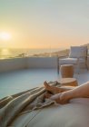 Femme pieds nus profitant du coucher de soleil panoramique vue sur l'océan sur le balcon de luxe — Photo de stock