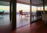 Maison de luxe vitrine balcon avec vue panoramique sur l'océan au coucher du soleil — Photo de stock