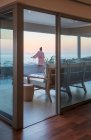 Femme profitant d'un coucher de soleil panoramique vue sur l'océan depuis le balcon de luxe — Photo de stock