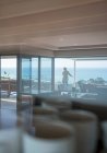 Mulher desfrutando ensolarado vista panorâmica do oceano na varanda de luxo — Fotografia de Stock