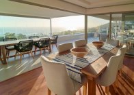 Maison ensoleillée vitrine salle à manger intérieure avec vue panoramique sur l'océan — Photo de stock