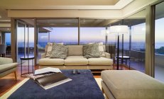 Главная витрина интерьер гостиной с видом на океан в сумерках — стоковое фото