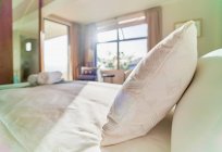 Pillow on bed in sunny bedroom — Stock Photo