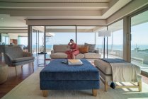 Donna rilassante con tablet digitale sul divano di casa vetrina soggiorno — Foto stock