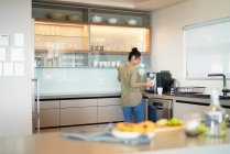 Donna che prepara espresso a macchina in cucina vetrina casa moderna — Foto stock