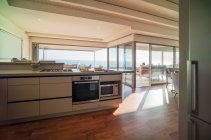 Moderna casa vetrina cucina con soleggiata vista sull'oceano — Foto stock