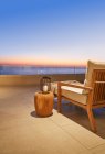 Lanterne et table d'appoint sur patio de luxe avec vue sur l'océan coucher de soleil — Photo de stock