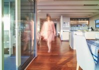 Donna sfocata a piedi in interni vetrina casa di lusso — Foto stock