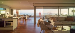Donna godendo vista panoramica soleggiata sull'oceano sul balcone di lusso — Foto stock