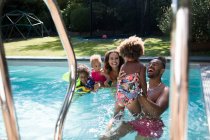 Familia feliz jugando en la piscina - foto de stock