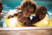 Retrato irmãs felizes no anel inflável na piscina ensolarada — Fotografia de Stock