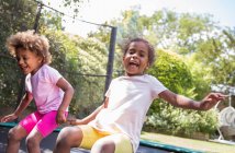 Retrato feliz brincalhão irmãs saltando no quintal trampolim — Fotografia de Stock