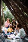 Família desfrutando de festa de chá no forte ao ar livre — Fotografia de Stock