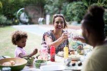 Счастливая семья наслаждается летним барбекю во внутреннем дворике — стоковое фото