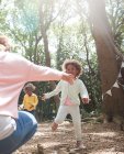 Mother and daughters playing in sunny summer woods — Stock Photo