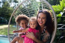Portrait heureux mère et filles en chaise balançoire d'été — Photo de stock