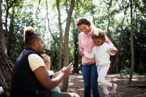 Happy family playing among trees in woods — Stock Photo