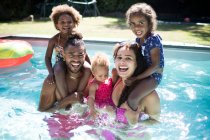 Ritratto felice famiglia eccitato giocare in soleggiata piscina estiva — Foto stock