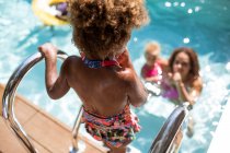 Мать смотрит дочь попасть в солнечный летний бассейн — стоковое фото