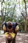 Brincalhão pai segurando filha de cabeça para baixo na floresta — Fotografia de Stock