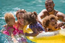 Портрет счастливой семьи, играющей в солнечном летнем бассейне — стоковое фото
