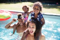 Ritratto famiglia giocosa nella soleggiata piscina estiva — Foto stock
