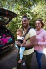 Portrait happy parents with toddler daughter outside car — Stock Photo