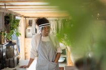 Frau mit Gesichtsschutz arbeitet in Gärtnerei — Stockfoto