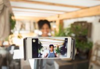 Female shop owner filming vlog with smart phone in plant nursery — Stock Photo