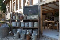Старовинні резервуари для поливу на виставці під знаком виходу з рослини — стокове фото
