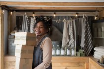 Porträt selbstbewusste Ladenbesitzerin trägt Kisten im Laden — Stockfoto