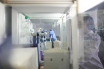 Científica usando pipeta en campana de humo en laboratorio - foto de stock