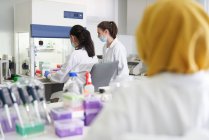 Cientistas do sexo feminino que trabalham na exaustão das emanações em laboratório — Fotografia de Stock