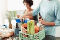 Couple unloading groceries from crates at kitchen counter — Stock Photo