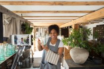 Щаслива власниця жіночого магазину, що знімає відеоблог зі смартфоном у розплідниках рослин — стокове фото