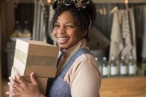 Portrait happy confident female shop owner with cardboard boxes — Stock Photo