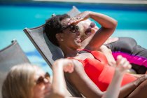 Felice anziano donne amiche prendere il sole a soleggiata estate a bordo piscina — Foto stock