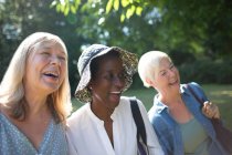 Fröhliche Seniorinnen lachen im sonnigen Sommergarten — Stockfoto