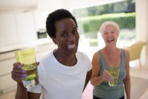 Portrait confident senior women friends drinking water after workout — Stock Photo