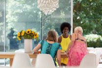 Happy senior women friends enjoying lunch at dining table — Stock Photo