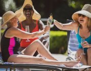 Happy senior women friends drinking champagne on sunny summer patio — Stock Photo