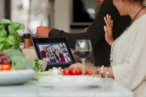 Chat vidéo familial sur écran de tablette numérique et préparation du dîner — Photo de stock