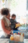 Mutter und kleine Tochter erhalten Lebensmittellieferung vor der Haustür — Stockfoto