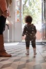 Menina bebê em pijama estrela na porta da frente — Fotografia de Stock