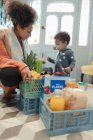 Mutter und kleine Tochter erhalten Lebensmittellieferung zu Hause — Stockfoto
