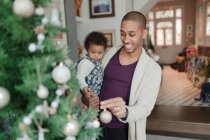 Happy father and baby daughter decorating Christmas tree — Stock Photo