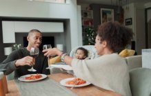 Glückliches Paar mit kleiner Tochter genießt Wein und Spaghetti — Stockfoto
