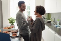 Счастливая пара разговаривает на кухне — стоковое фото