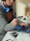 Mulher com contas de pagamento de cartão de crédito online no laptop — Fotografia de Stock