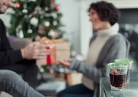 Happy couple opening Christmas gifts in living room — Stock Photo